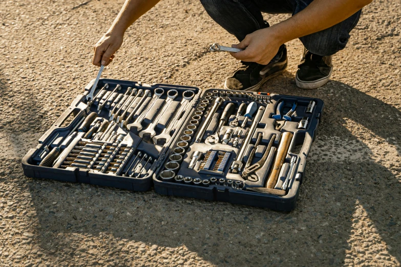 a man kneeling down in front of a set of tools