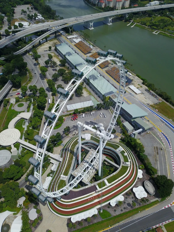 a large ferris wheel surrounded by other structures near the water