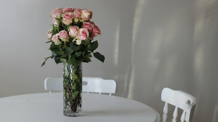 a vase filled with roses sits on a table