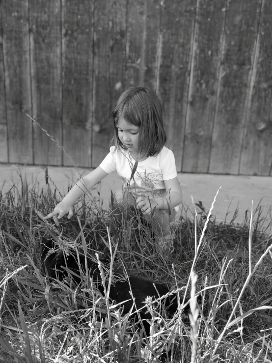 a girl is sitting in the grass holding soing