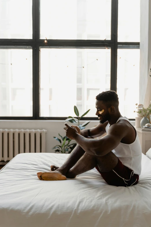 a man sitting on a bed looking at the camera