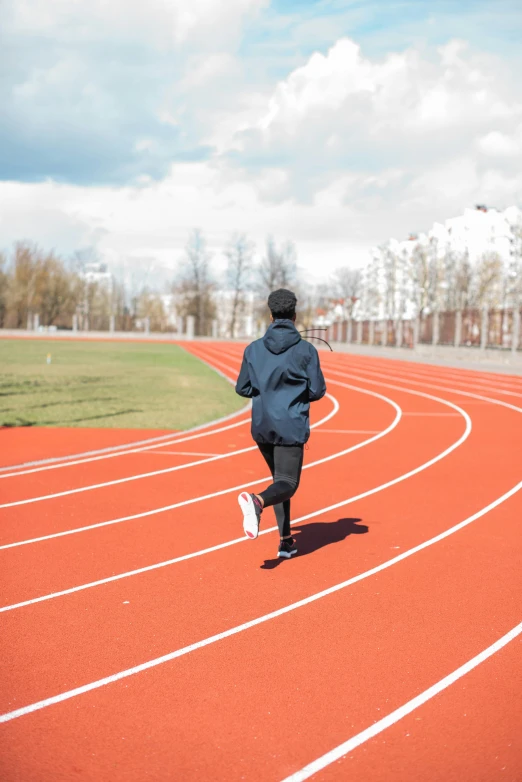 a person in a raincoat running along a track