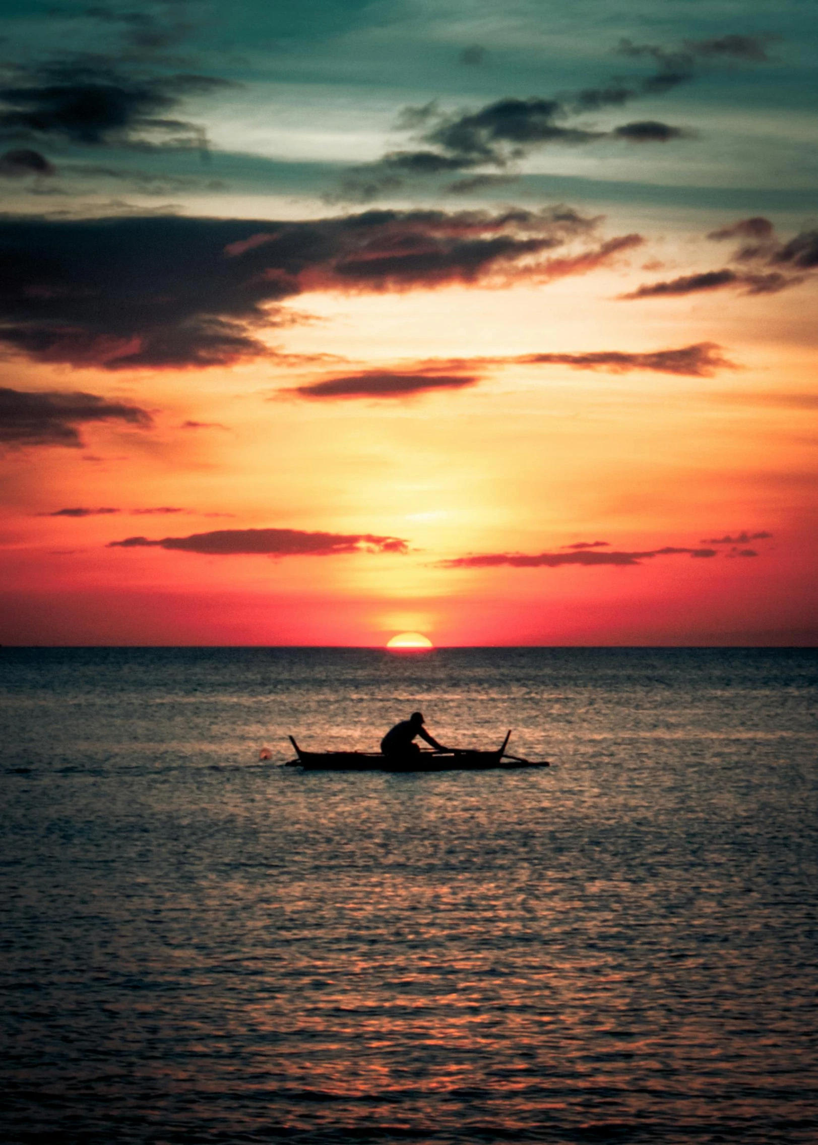 a person sitting in a boat on a body of water during the day