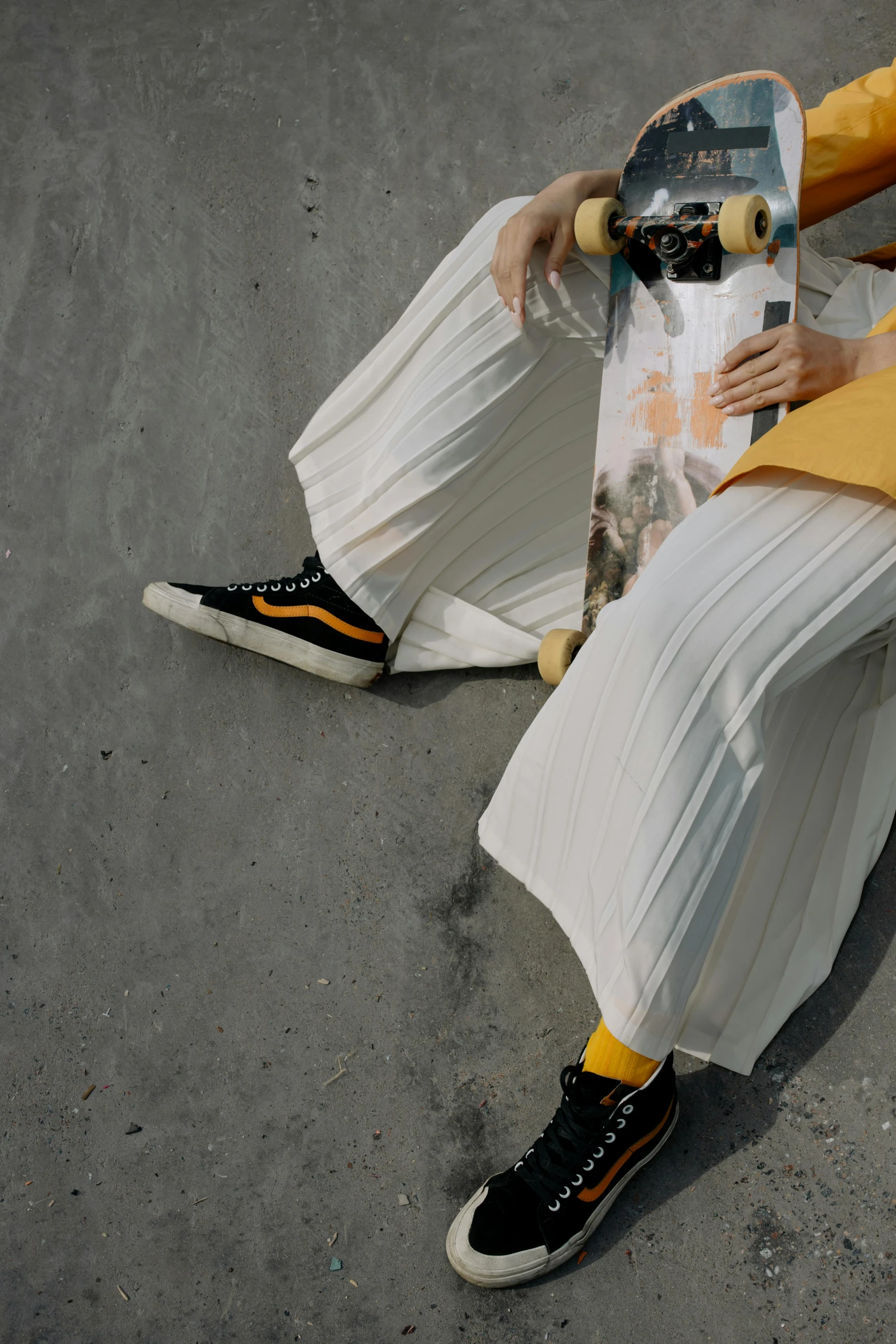 a woman is sitting with a skateboard in hand