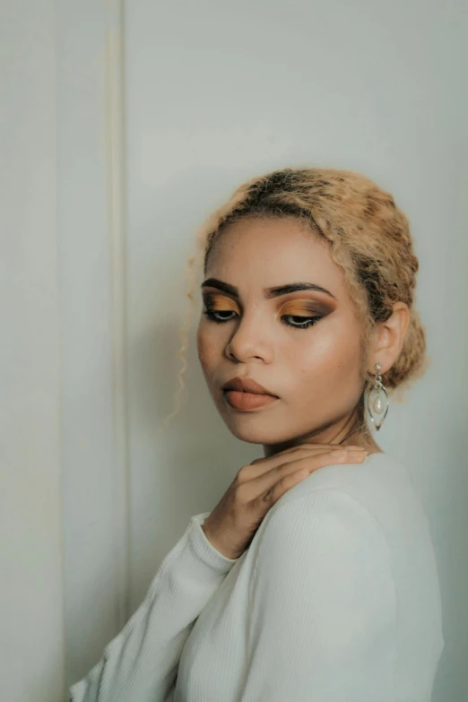 a woman with blonde hair and eyeshade wearing earrings