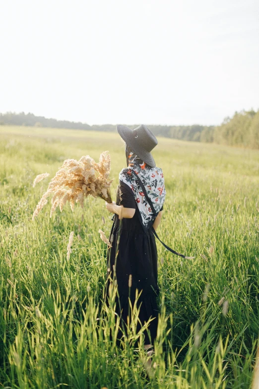 a woman in black is walking in the field