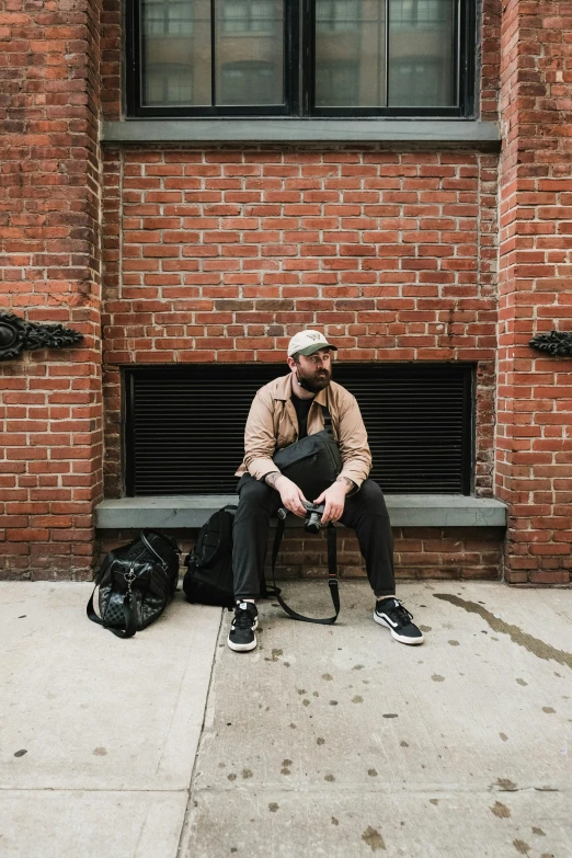 a man sitting on a bench near a bag of luggage