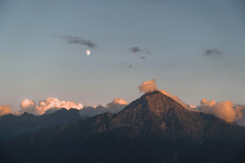 there is a mountain with white clouds in the sky