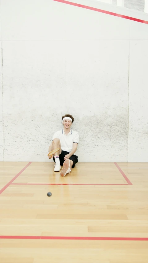 a woman with a white ball sits on the floor