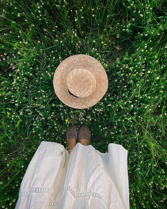 a person is standing on grass wearing a hat