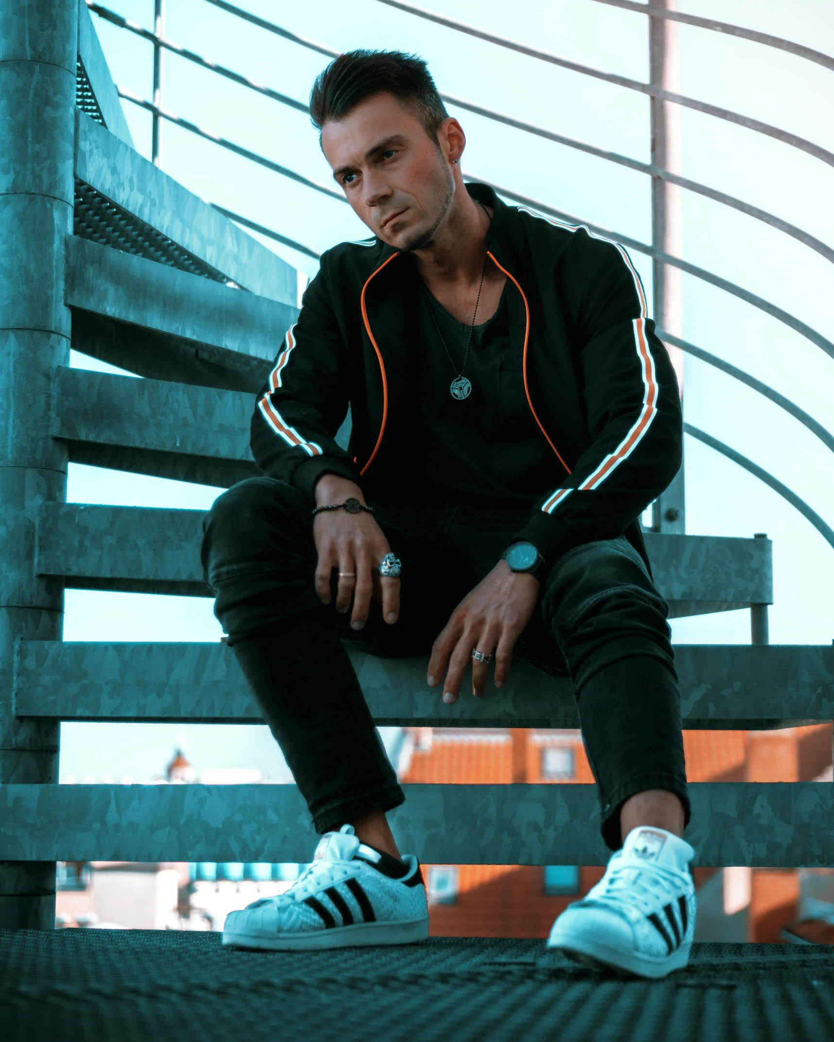 a man in black sweatshirt sitting on wooden bench