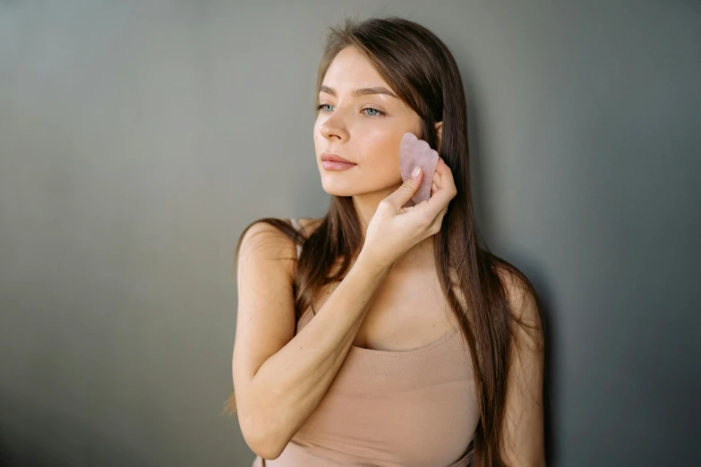 woman putting the clean skin on her face with clay