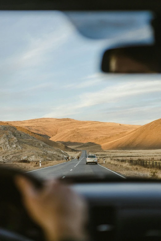 a car's dashboard as the view of a road through a window