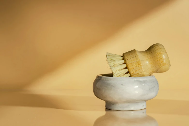 a yellow toothbrush in a white ceramic holder