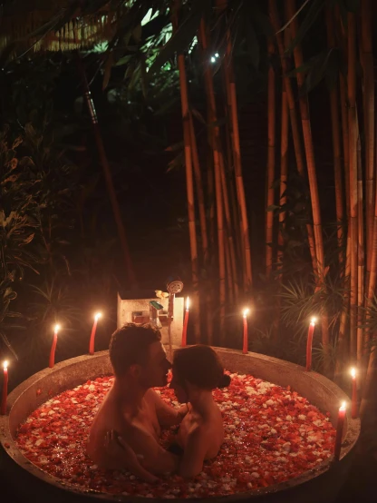 the couple are in the jacuzzi with candles