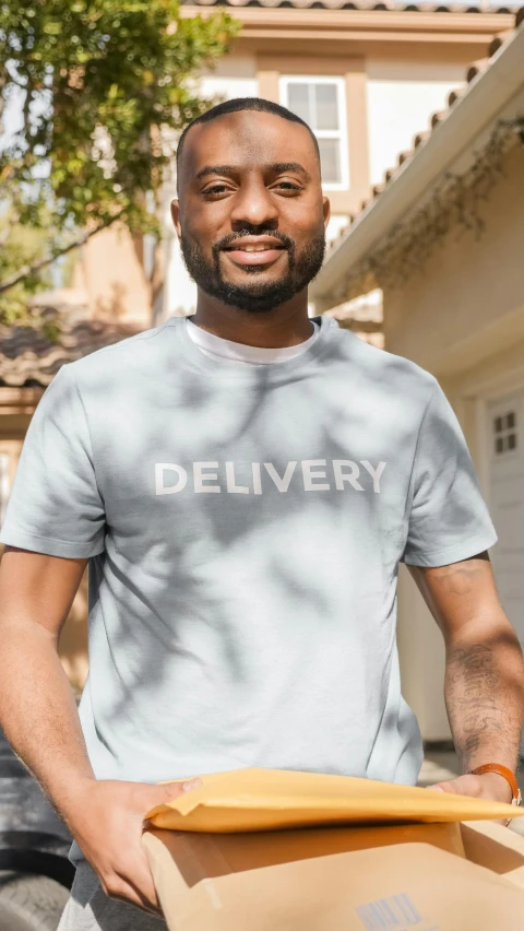 a man holding a box of pizza with the words delivery on it