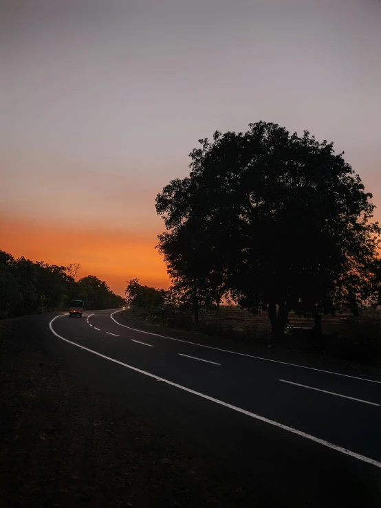 a road at sunset that is empty and winding