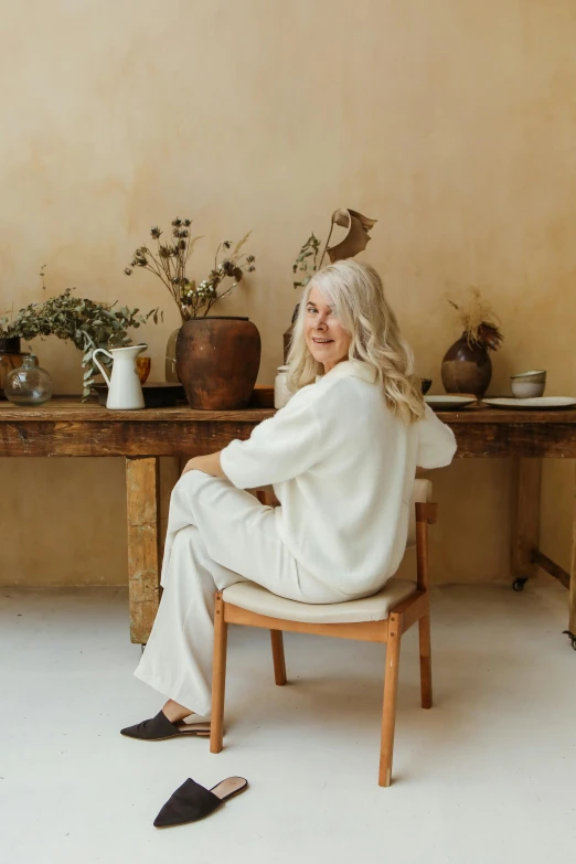 an old woman sitting on a chair in a room