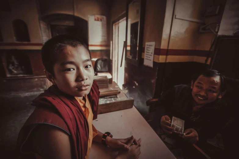 a boy in a robe taking a selfie with his friend