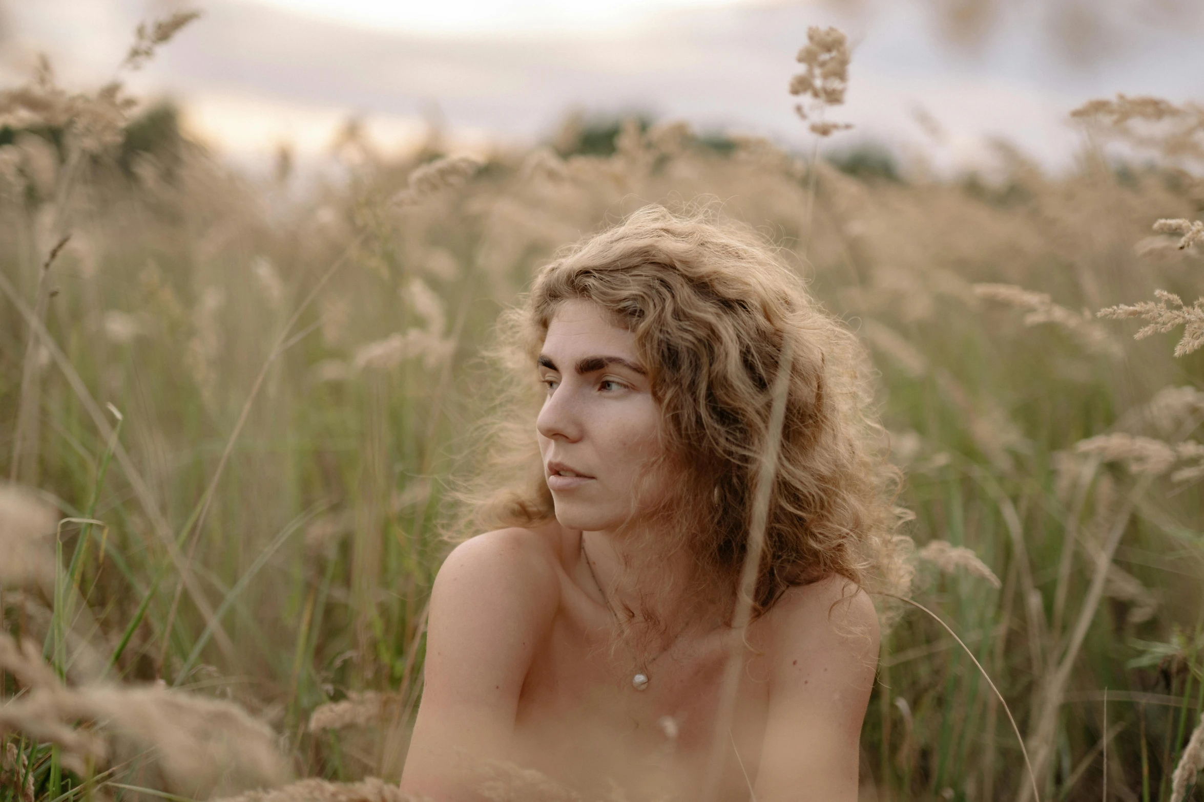 shirtless young woman looking into the distance