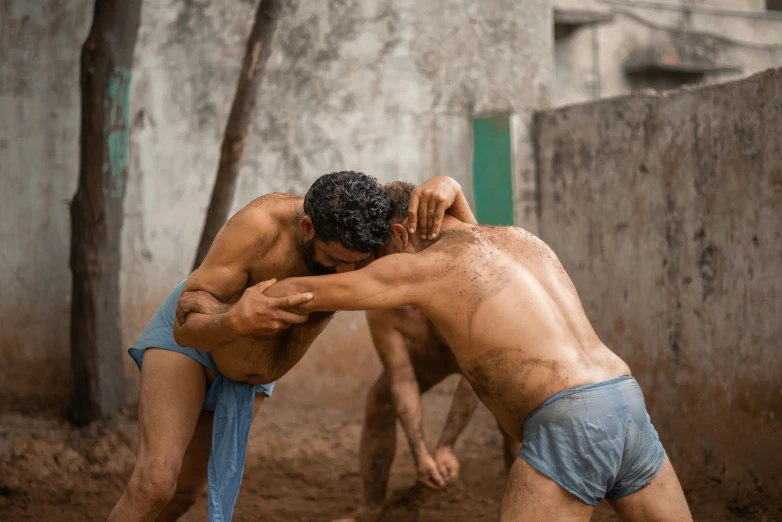 two  men wrestling in the dirt