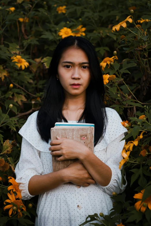 a woman standing in a field with flowers