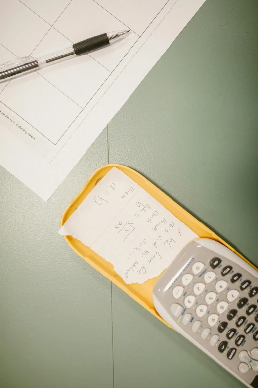 a calculator and pen on top of a desk