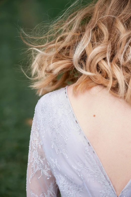 the back of a woman's head with hair blowing in the wind