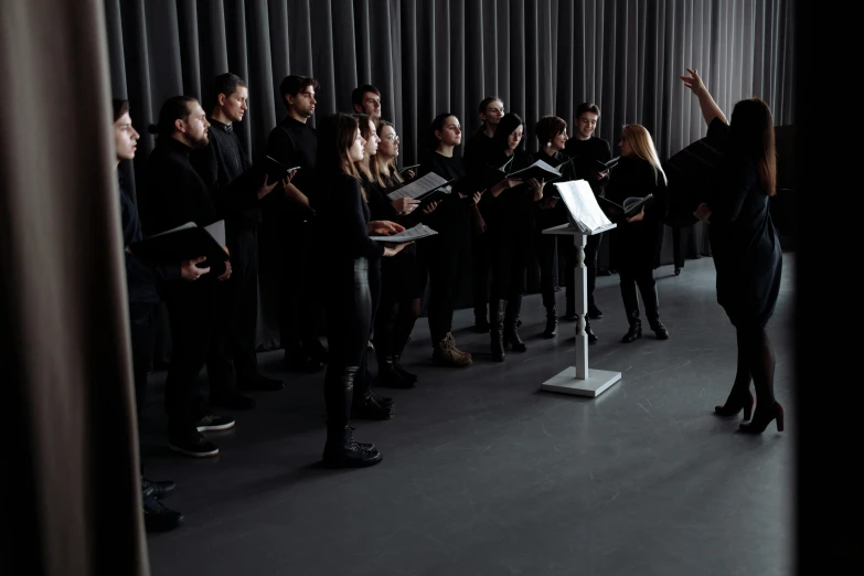 an orchestra band standing on stage with a conductor