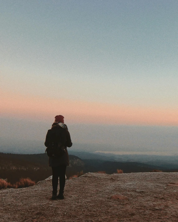 a man that is standing up on top of a mountain