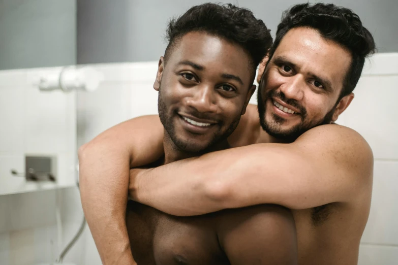 two men are posing for a picture while in the shower