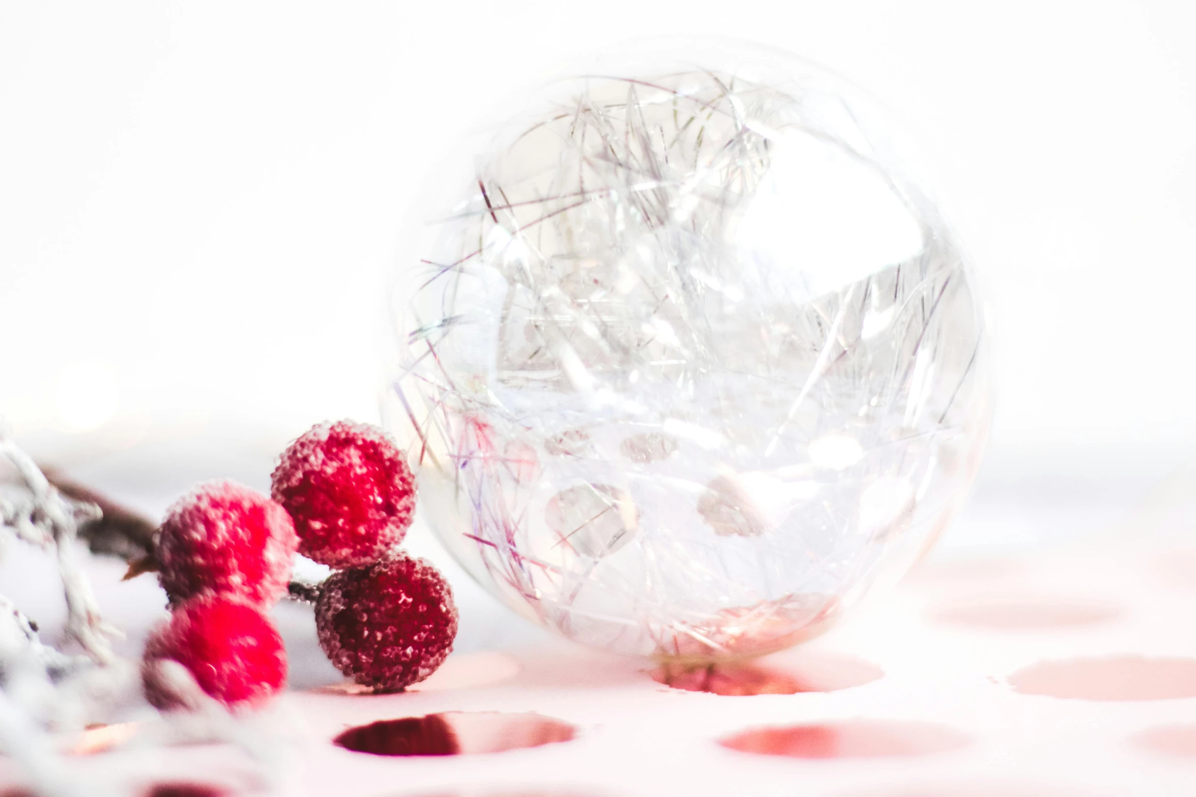 two raspberries sitting on top of a table next to a glass vase