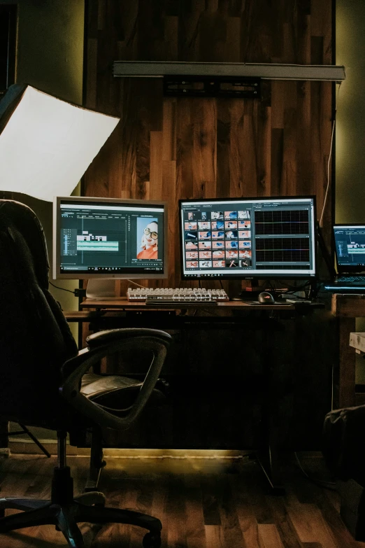 two monitors sit on a desk behind a chair