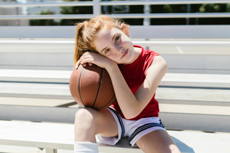  sitting on bleachers holding basketball