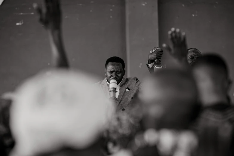 a man holding his hand up while standing in front of a crowd