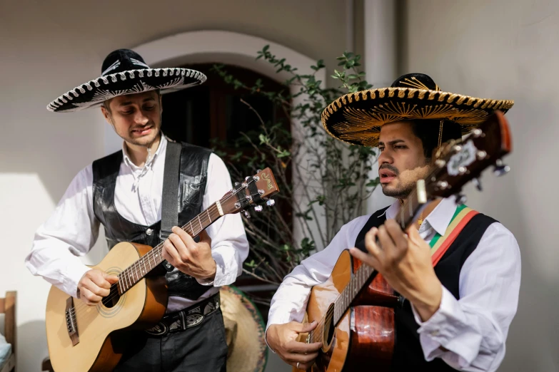 two men wearing sombreros and playing guitars