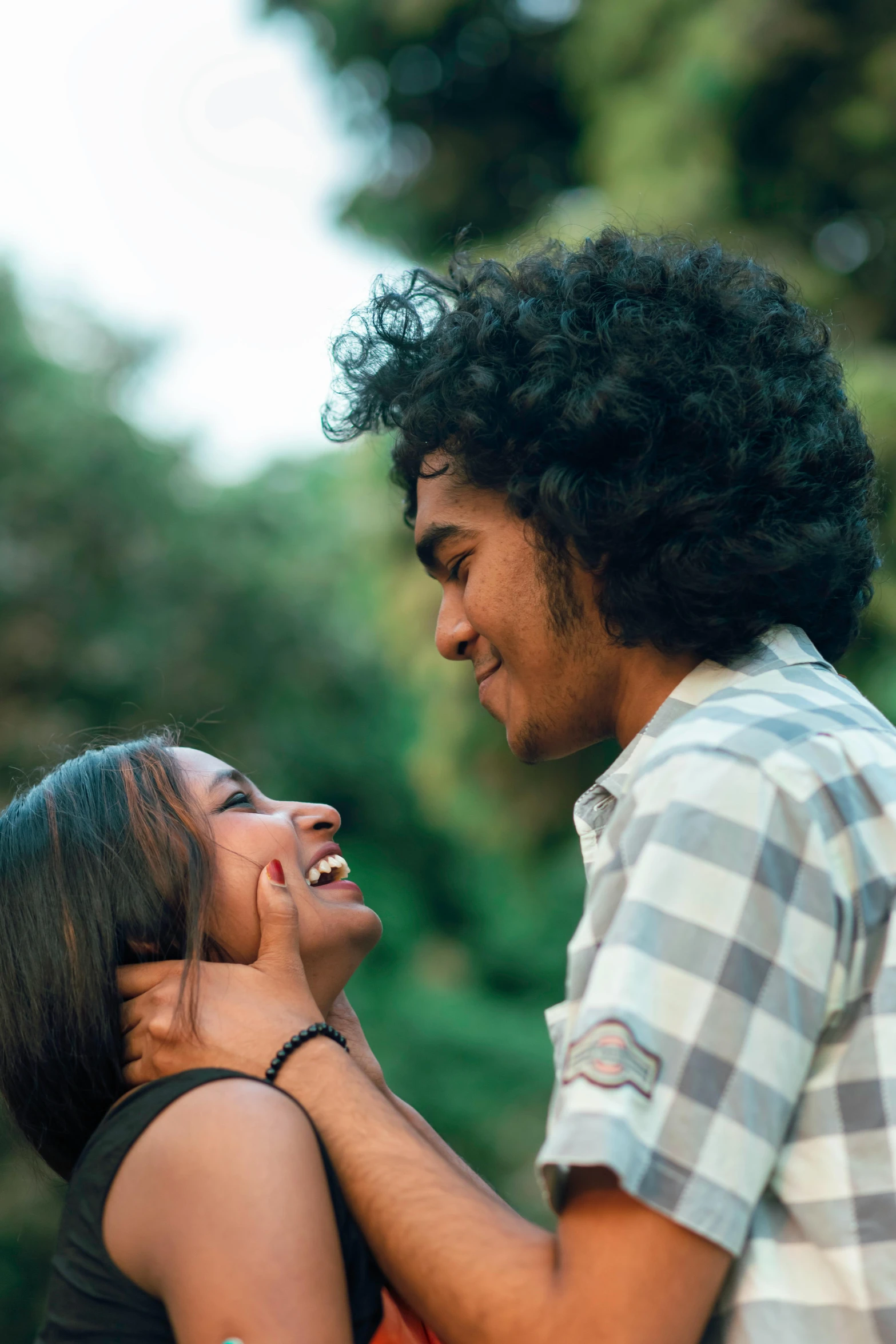 a young couple laughing and joking in the woods