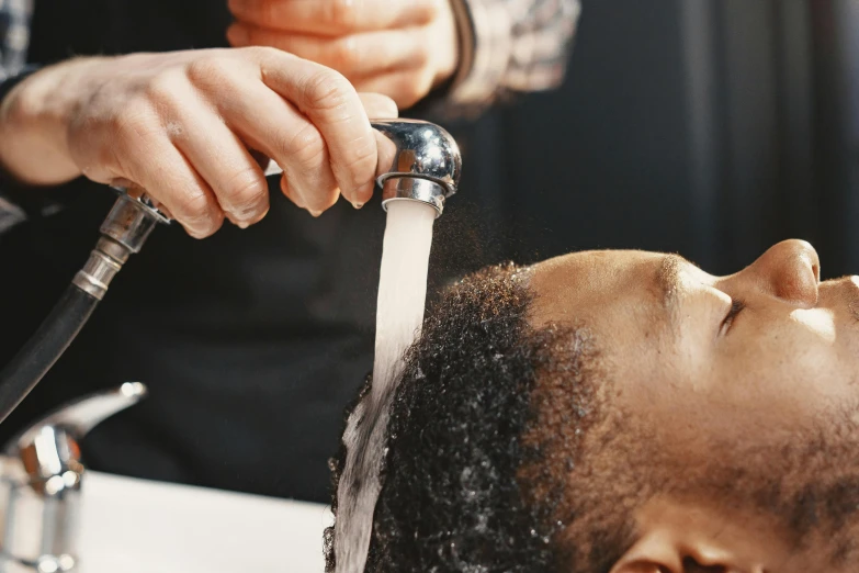 a man is getting a haircut from a woman