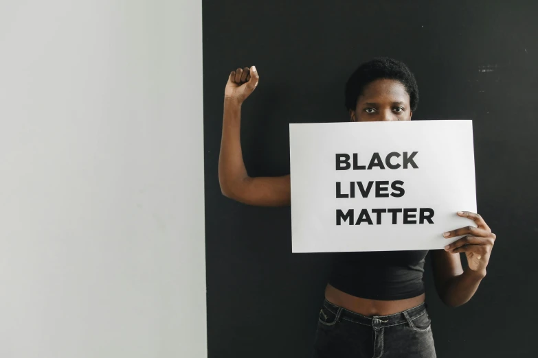 a woman holding up a sign that reads black lives matter