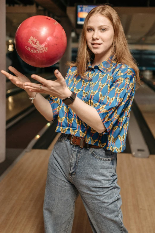 a man holding up a red bowling ball