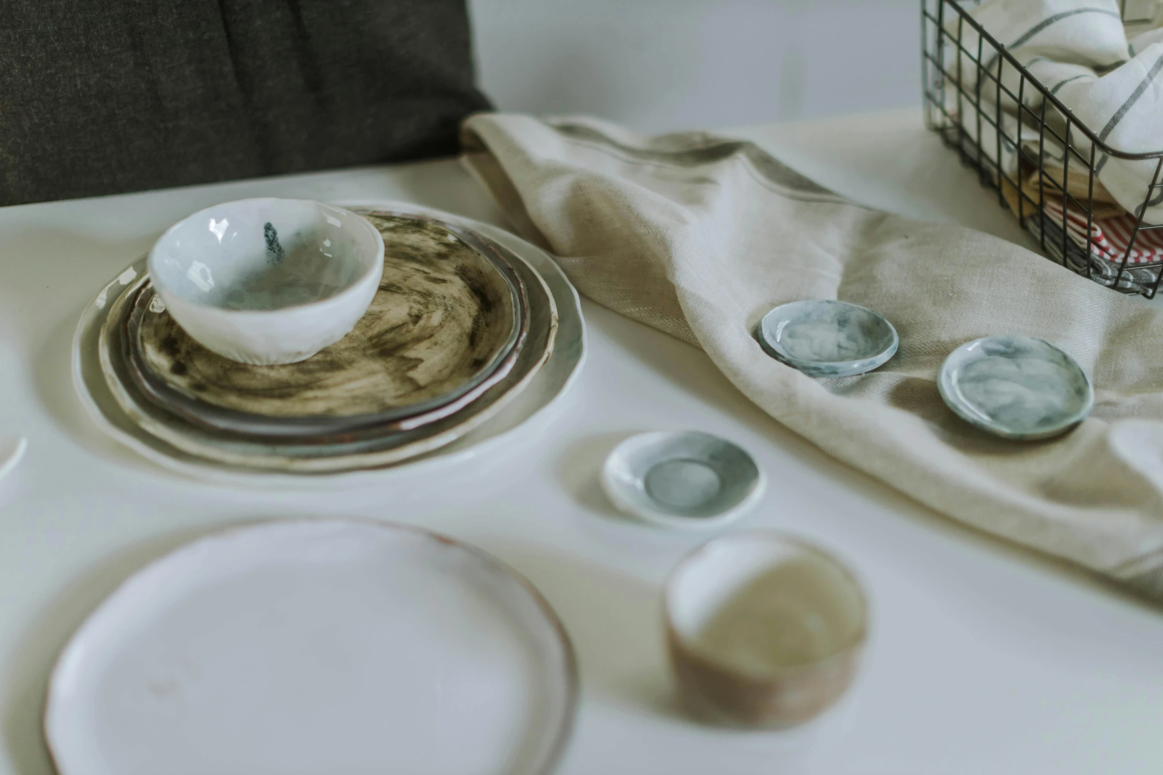 three plates, one silver and one white and the other has a basket with eggs in it