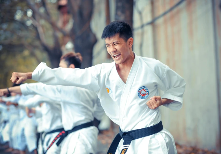 a man is doing karate with a bunch of other men