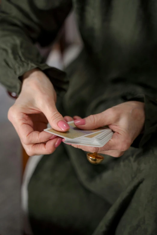 a person wearing green holding onto some sort of coin