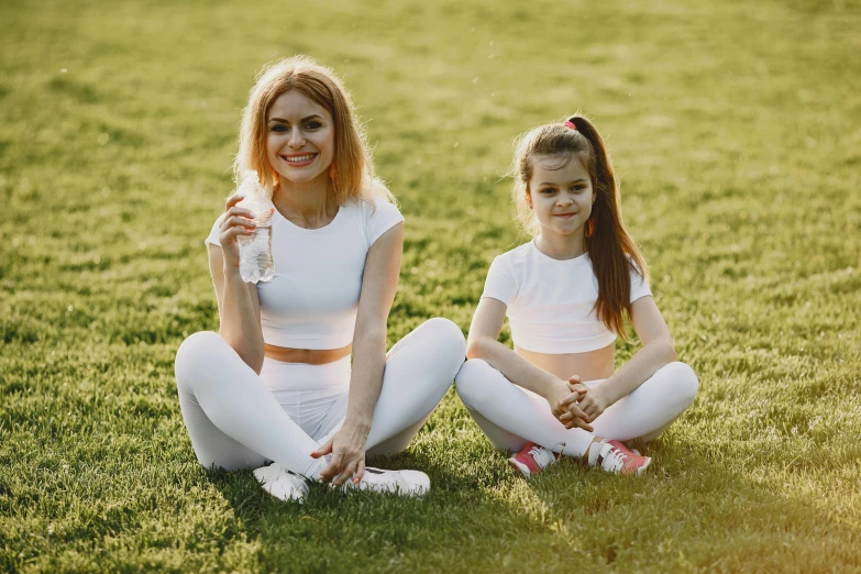 two women pose for the camera on a grassy field