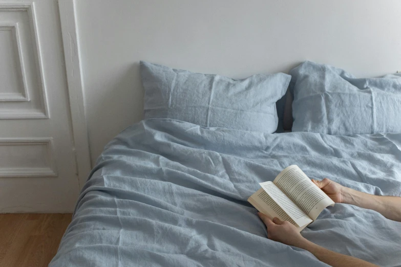 there is a person reading a book on the bed