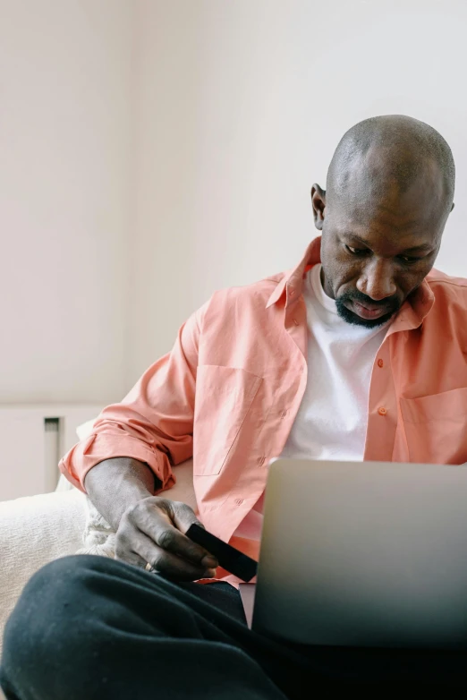 a man sitting on top of a bed in front of a laptop