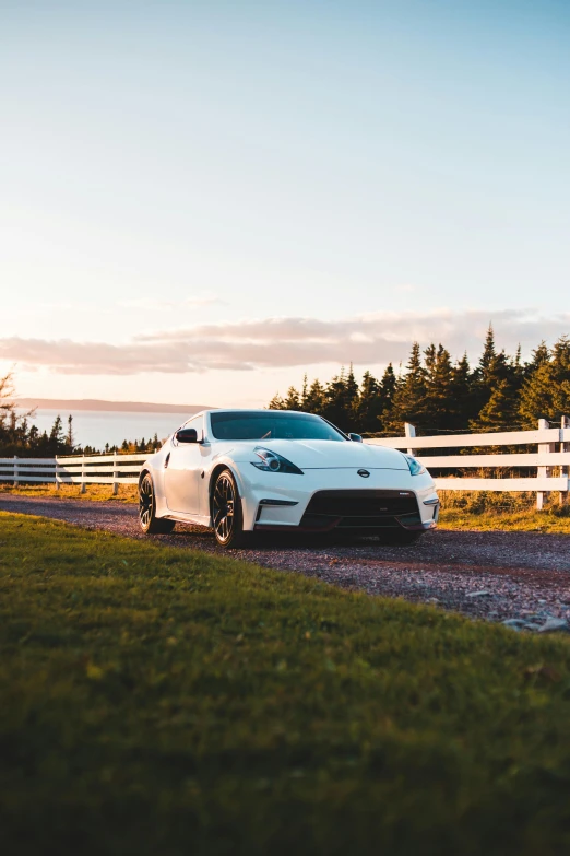 a white sports car driving down the road