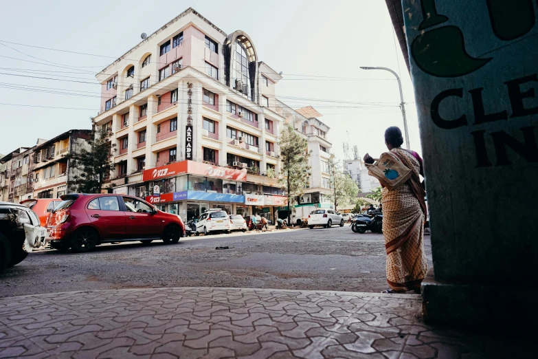 a person in white is standing on the side of a street