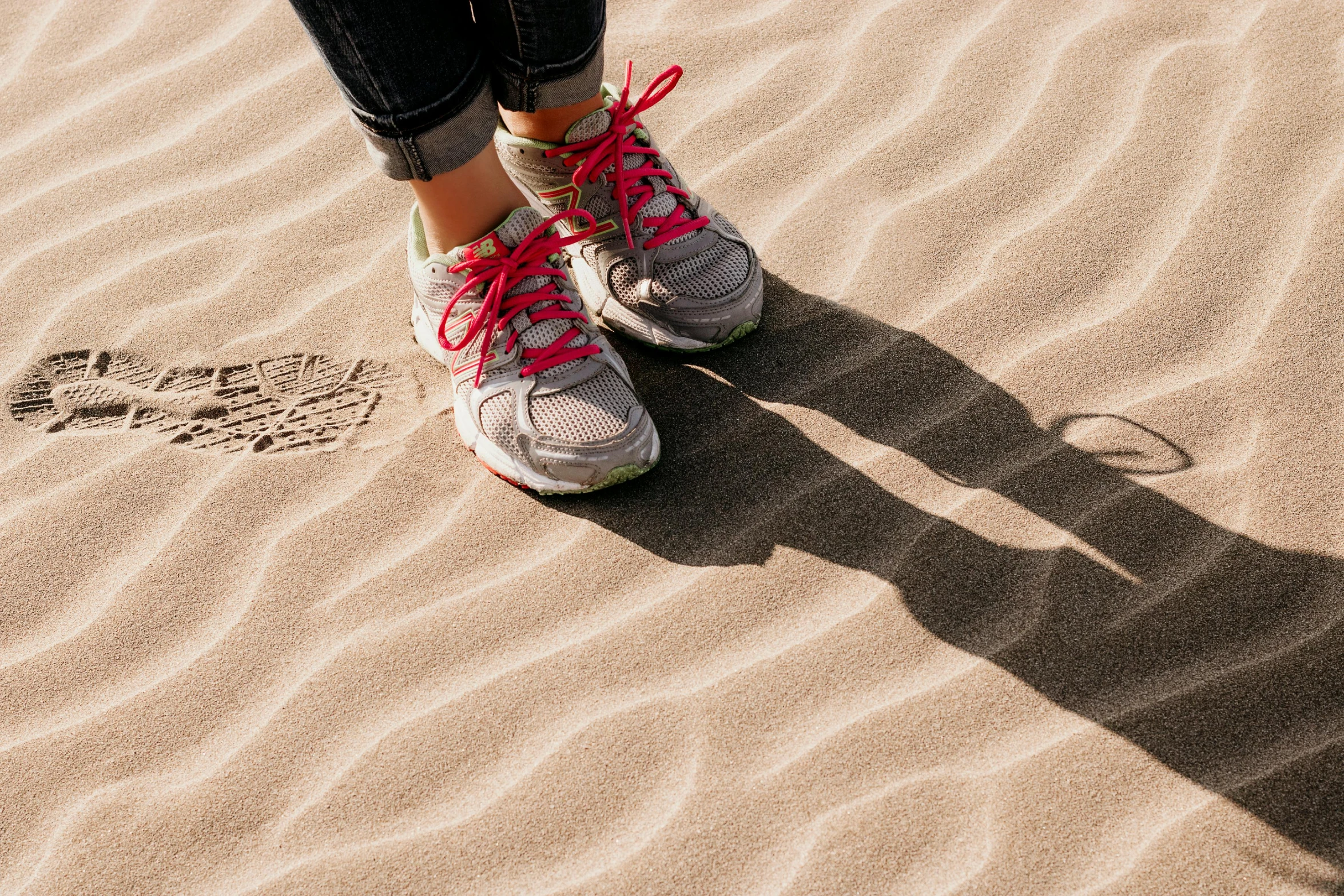 someone is wearing sneakers on top of sand