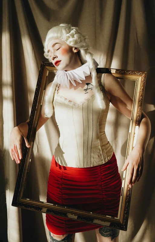 a woman in red and white corset posing behind a picture frame